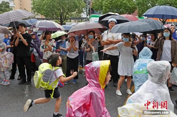 資料圖：家長在校外接孩子放學(xué)回家。殷立勤 攝